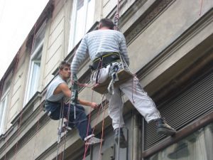 Workman Hanging Banner on Building