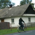 Man riding bike near houses