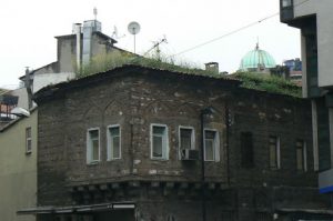 Old masonry house among newer buildings--so old