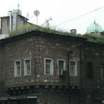 Old masonry house among newer buildings--so old