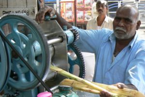 Crushing sugar cane into sugar water,