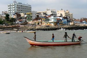 Kanyakumari - fishermen return to the port. Tall building in