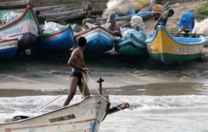 Kanyakumari - colorful fishing boats and a sinuous crew member.