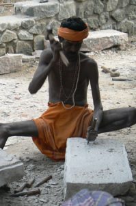 Kanyakumaristoneworker at the foot of the statue of the