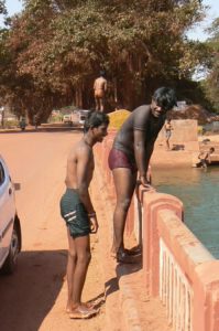 Kids diving and swimming from a bridge in Goa.