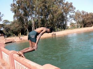 Kids diving and swimming from a bridge in Goa.