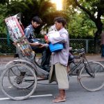 Dhaka - rikshaw rider buying water from a vendor.