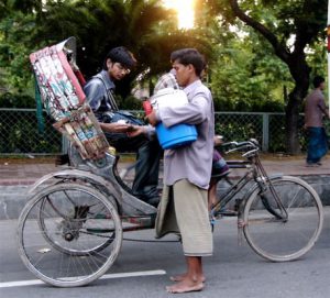 Dhaka - rikshaw rider buying water from a vendor.