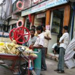 Dhaka - sugar cane grinder selling the sweet drink