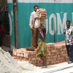 Dhaka - carrying bricks at a construction site.