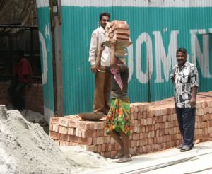 Dhaka - carrying bricks at a construction site.