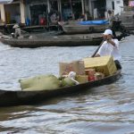 Mekong Delta - man conducting commerce by boat.