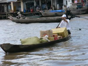 Mekong Delta - man conducting commerce by boat.