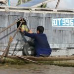 Selling melons to a boat resident