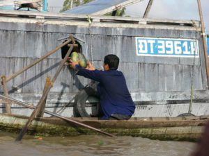 Selling melons to a boat resident