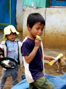 Rural farming village near Dalat - child eating candy