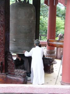 Nha Trang - Ancient bronze bell at Buddhist shrine; tourists sit