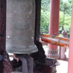 Nha Trang - Ancient bronze bell at Buddhist shrine; tourists sit