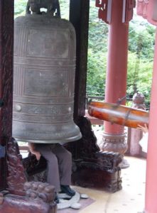 Nha Trang - Ancient bronze bell at Buddhist shrine; tourists sit