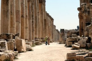 People walking down by the amazing row of columns