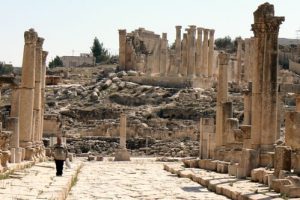 Man walking through history along side the columns and stone