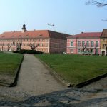 Residential and commercial buildings surround a square.