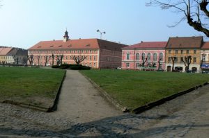 Residential and commercial buildings surround a square.