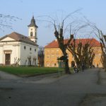 Church and residential building on a square.