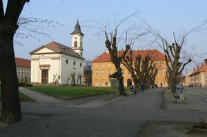 Church and residential building on a square.