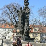 Charles Bridge statue and souvenir vendor.