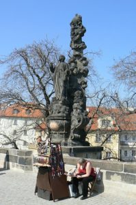 Charles Bridge statue and souvenir vendor.