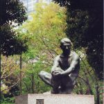 Pensive sculpture in a park.