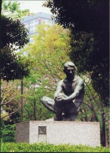Pensive sculpture in a park.