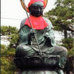 Buddha statue at the Zenko-ji Buddhist Temple holding symbolic objects.