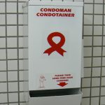 Empty condom dispenser in a museum restroom.