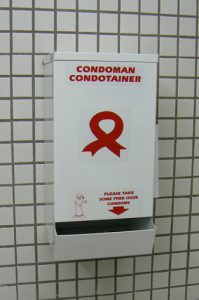 Empty condom dispenser in a museum restroom.