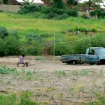 Derelict vehicle by a residence.