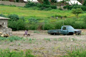 Derelict vehicle by a residence.