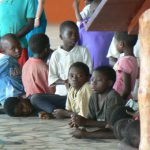 Children at church service: curious, wondering, amused.