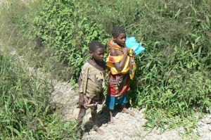 Children watching the train; girls appear better dressed than boys.