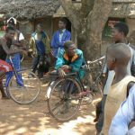 Local village people hanging out with their bicycle taxis;  man