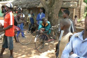 Local village people hanging out with their bicycle taxis;  man