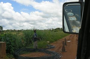 Workers laying cable along the road.