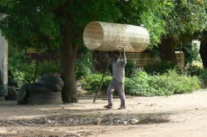 Basket weaver taking his wares to the Mangochi, market.