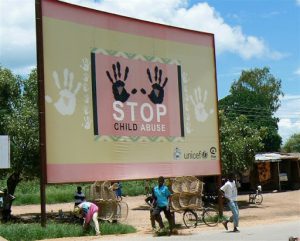 A billboard from UNICEF urging child abuse prevention;  Under the