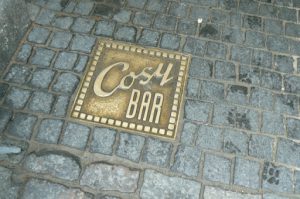 Brass ground plate at the entry to Cosy Bar.