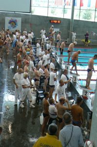 Officials and swimmers at start end of pool.