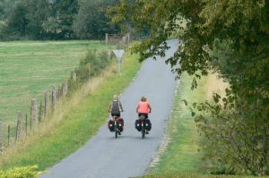 Cyclists pedal down a quiet country road outside Grandpre