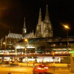 Cathedral at night behind train station