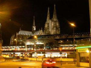 Cathedral at night behind train station